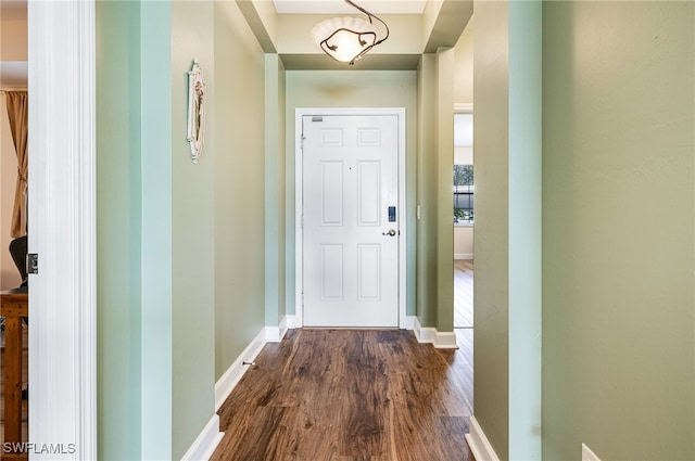 doorway to outside featuring dark wood-type flooring and baseboards