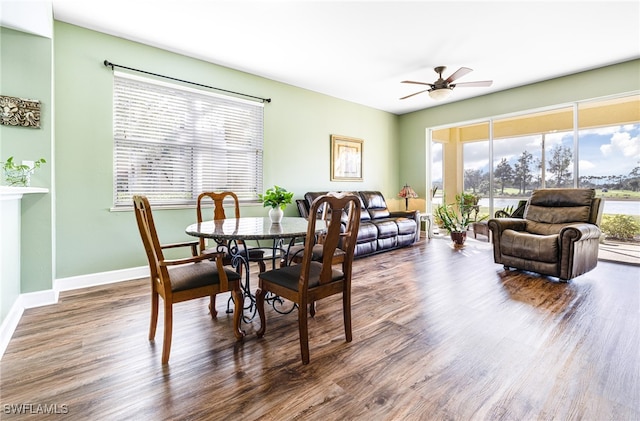 dining area featuring dark wood-style floors, a ceiling fan, and baseboards