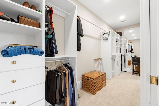 walk in closet with light colored carpet