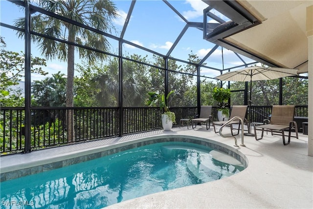 view of pool with glass enclosure and a patio area