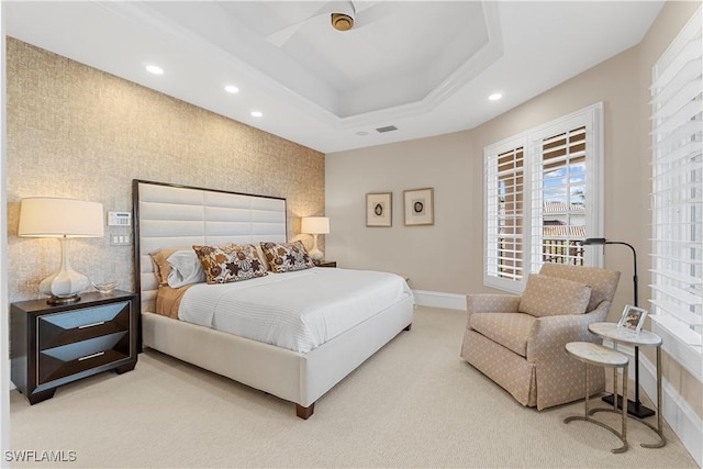 bedroom with carpet flooring, a tray ceiling, and ceiling fan