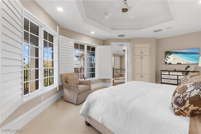 carpeted bedroom with a raised ceiling, ceiling fan, and a closet