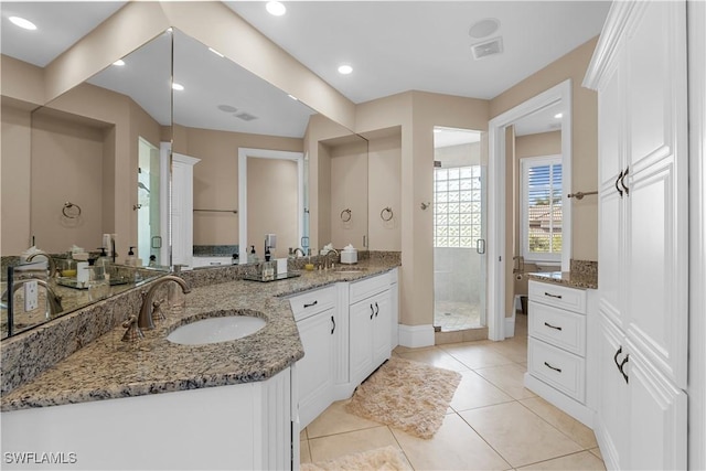 bathroom with tile patterned floors, vanity, and walk in shower