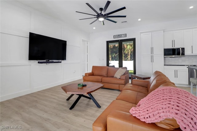 living room featuring french doors, light hardwood / wood-style floors, and ceiling fan