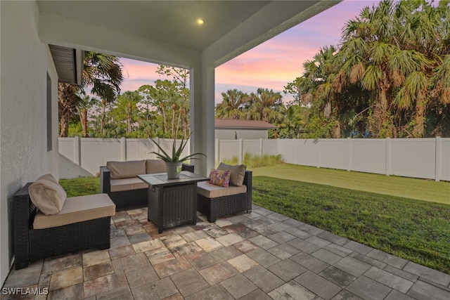 patio terrace at dusk featuring an outdoor hangout area and a lawn