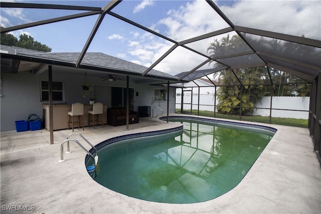 view of pool featuring exterior bar, a lanai, ceiling fan, and a patio area