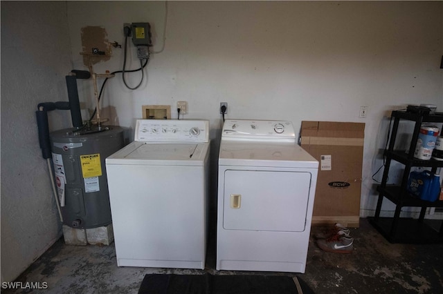 clothes washing area featuring electric water heater and washer and clothes dryer