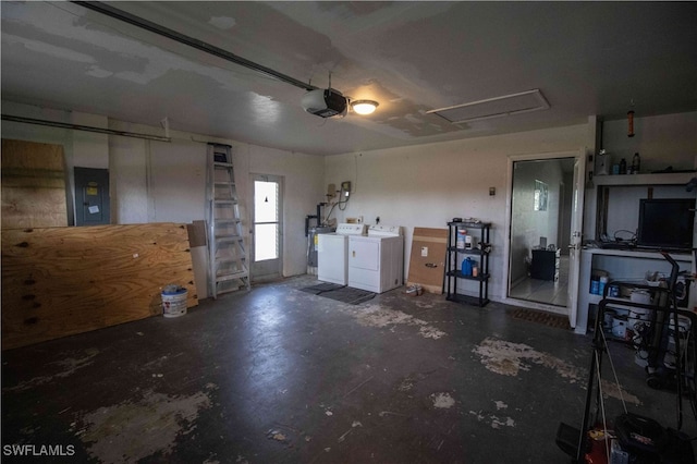 garage featuring electric panel, a garage door opener, and independent washer and dryer