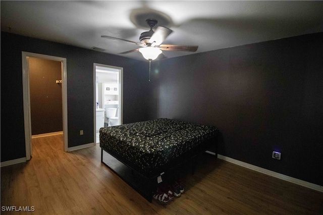 bedroom with ensuite bath, ceiling fan, and hardwood / wood-style flooring