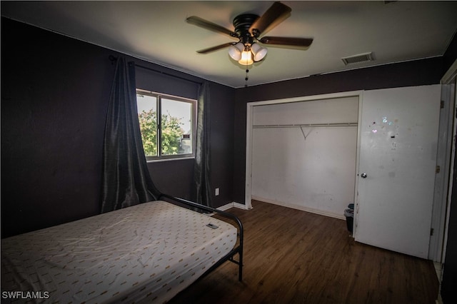 bedroom featuring dark hardwood / wood-style flooring, a closet, and ceiling fan