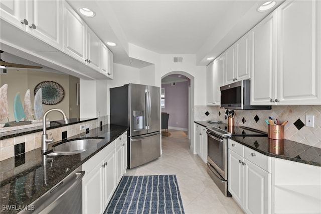 269 Vintage Bay Dr Unit C-13, Marco Island, FL 34145 - kitchen featuring appliances with stainless steel finishes, arched walkways, white cabinets, backsplash, and light tile patterned floors
