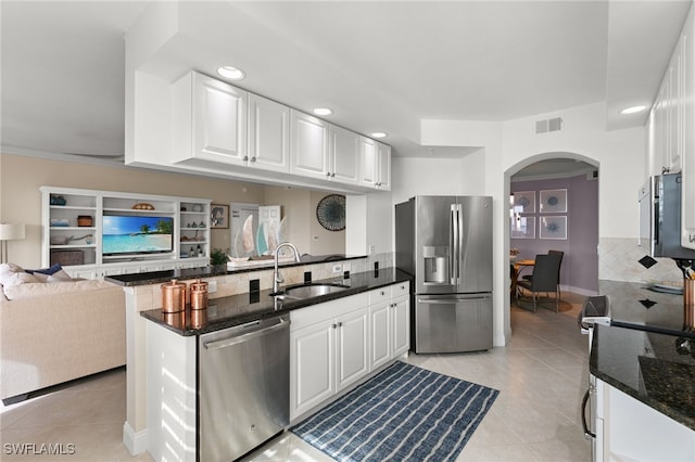 269 Vintage Bay Dr Unit C-13, Marco Island, FL 34145 - kitchen with appliances with stainless steel finishes, arched walkways, backsplash, a peninsula, and dark stone counters