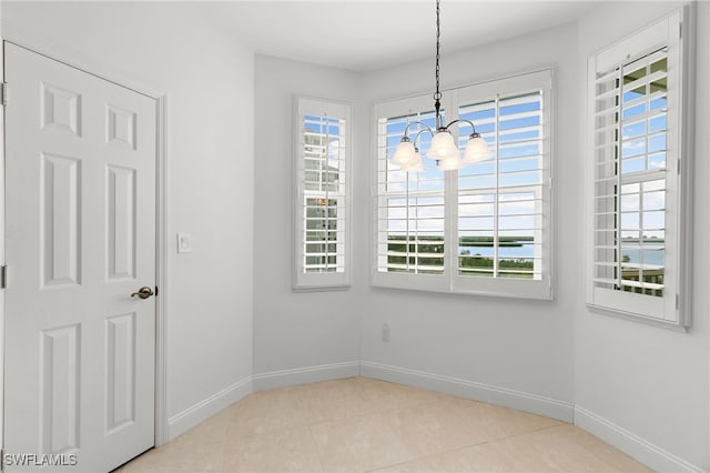 unfurnished room with light tile patterned flooring and a chandelier