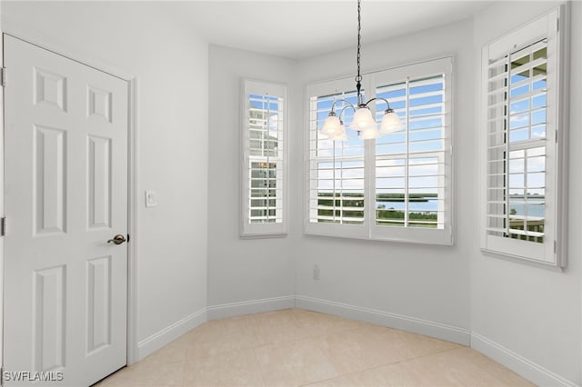 269 Vintage Bay Dr Unit C-13, Marco Island, FL 34145 - unfurnished dining area featuring plenty of natural light, a chandelier, and tile patterned floors