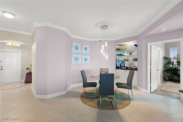 dining space with light tile patterned floors and crown molding