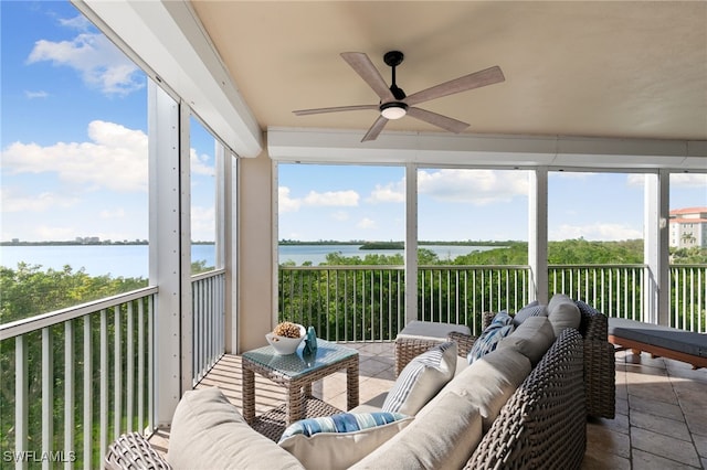 sunroom / solarium with a water view and ceiling fan