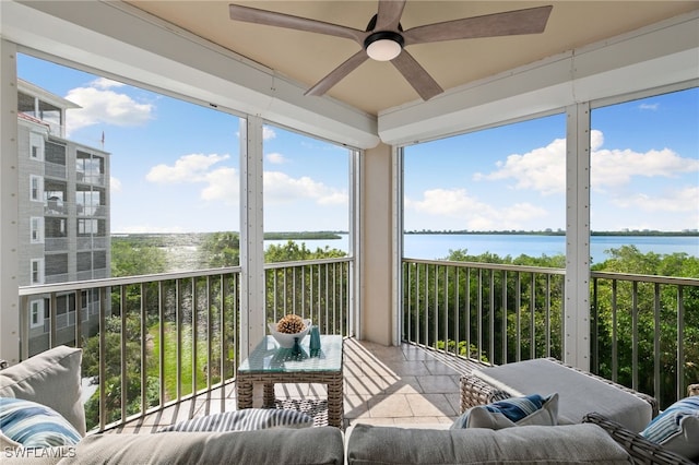 sunroom / solarium with a water view and ceiling fan