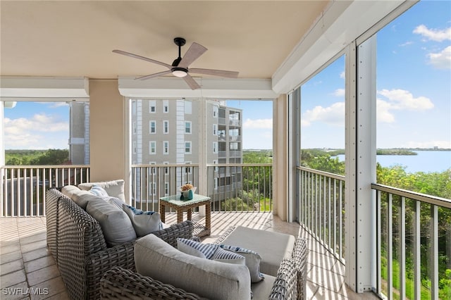 sunroom / solarium with ceiling fan, a water view, and a wealth of natural light