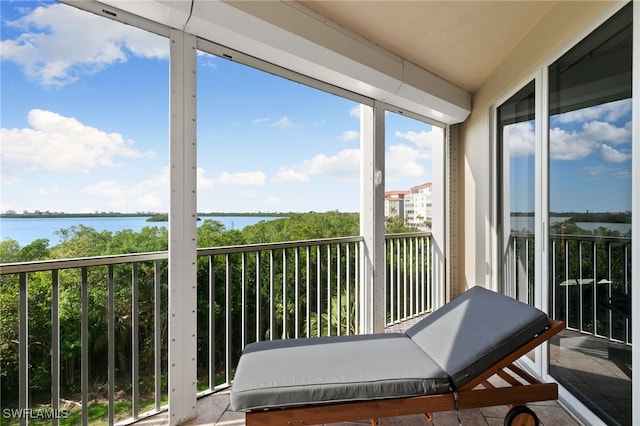 sunroom featuring a water view and a healthy amount of sunlight