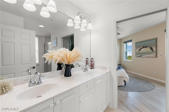 bathroom with hardwood / wood-style flooring, vanity, walk in shower, and a chandelier