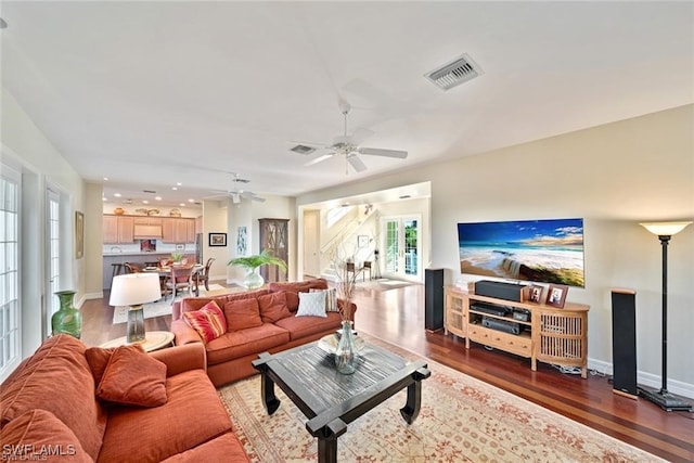 living room with ceiling fan and dark wood-type flooring