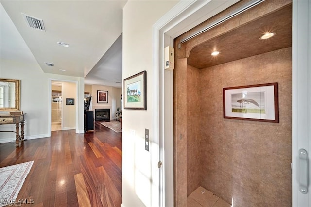 corridor with dark hardwood / wood-style flooring