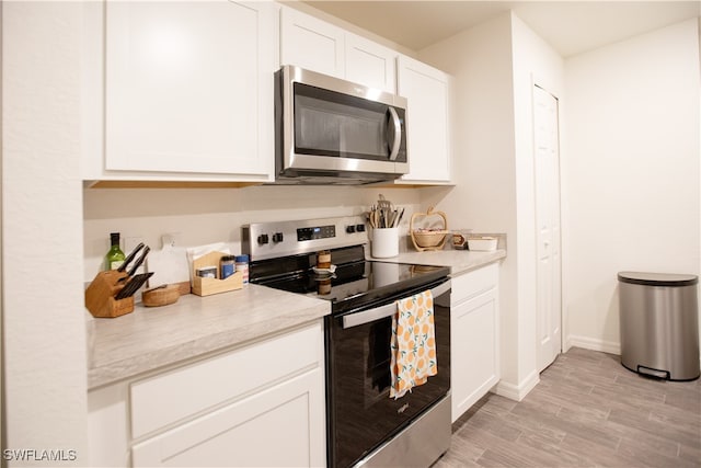 kitchen with white cabinetry, light hardwood / wood-style flooring, and stainless steel appliances