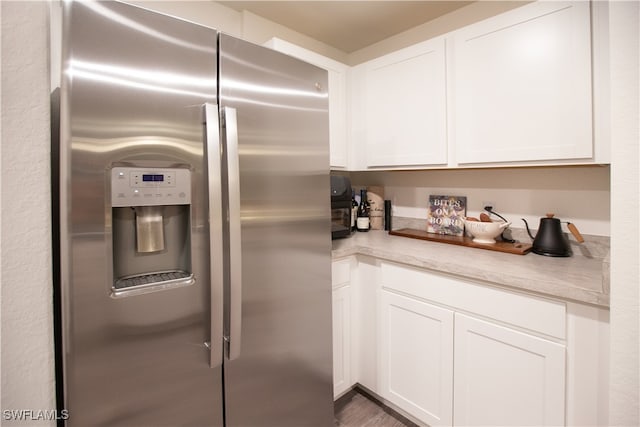 kitchen featuring white cabinetry, stainless steel fridge, and dark hardwood / wood-style floors