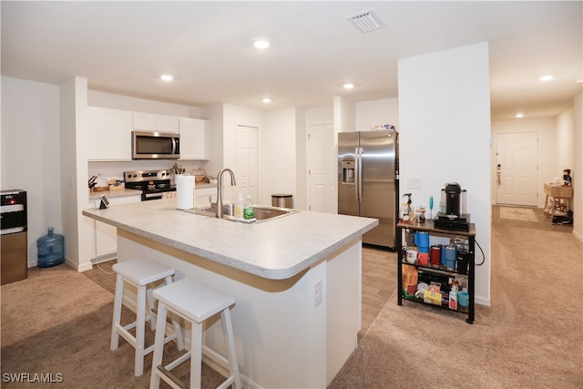 kitchen with sink, white cabinetry, an island with sink, and appliances with stainless steel finishes