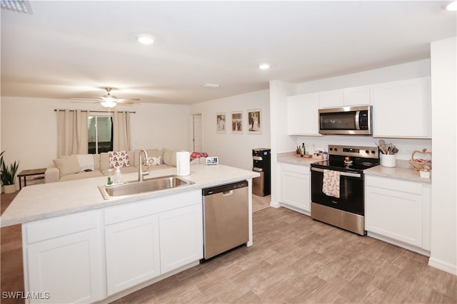 kitchen featuring appliances with stainless steel finishes, light hardwood / wood-style flooring, white cabinetry, and sink