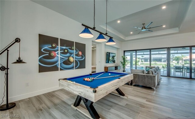 game room with french doors, a raised ceiling, ceiling fan, hardwood / wood-style floors, and pool table