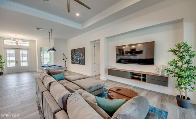 living room with french doors, light wood-type flooring, ornamental molding, a raised ceiling, and pool table