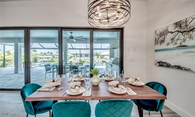 dining space with hardwood / wood-style floors and ceiling fan with notable chandelier