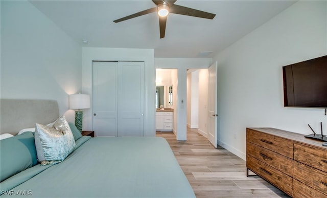 bedroom with ensuite bath, ceiling fan, a closet, and light wood-type flooring