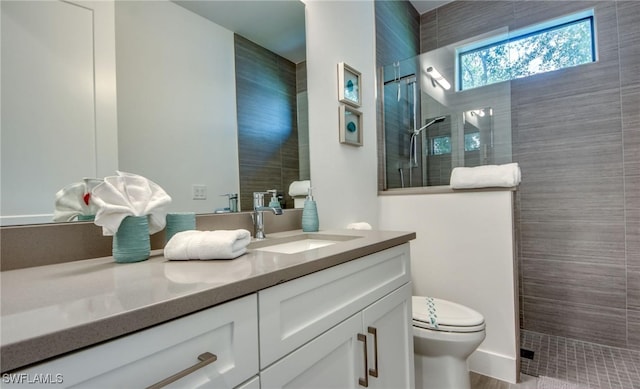 bathroom featuring tiled shower, wood-type flooring, vanity, and toilet