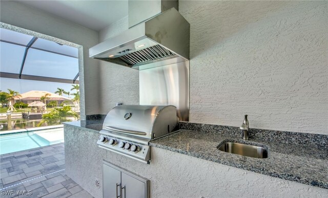 view of patio / terrace with area for grilling, glass enclosure, and sink