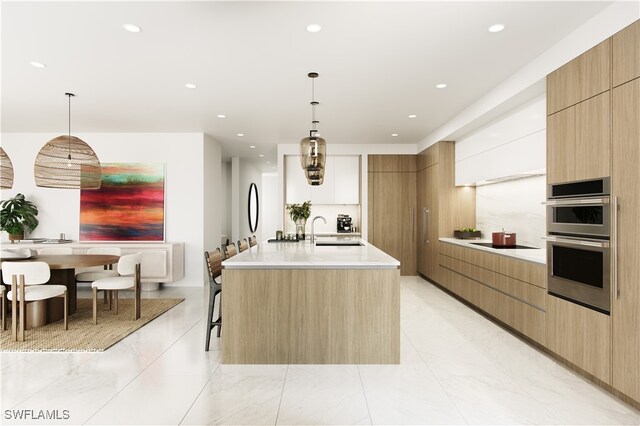 kitchen featuring decorative light fixtures, white cabinetry, double oven, and a large island