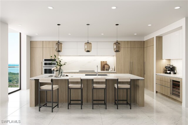 kitchen featuring an island with sink, pendant lighting, white cabinets, and beverage cooler