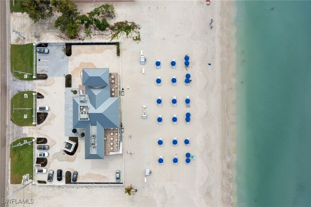 birds eye view of property with a water view and a view of the beach