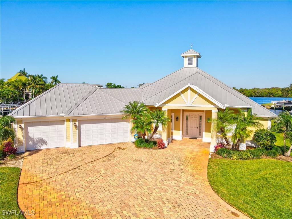 view of front facade featuring a water view, a front yard, and a garage