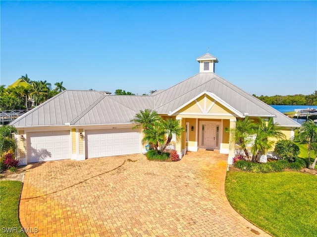 view of front facade featuring a water view, a front yard, and a garage