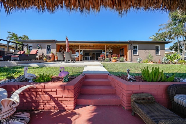 rear view of house with an outdoor living space, a yard, and a patio