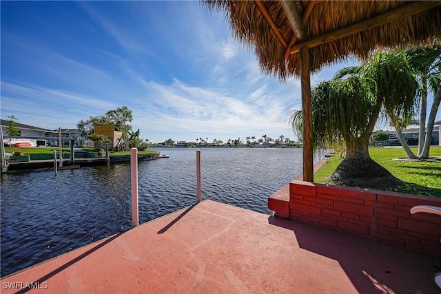 dock area with a lawn and a water view