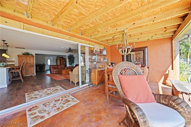 dining room with beamed ceiling, ceiling fan with notable chandelier, and hardwood / wood-style flooring