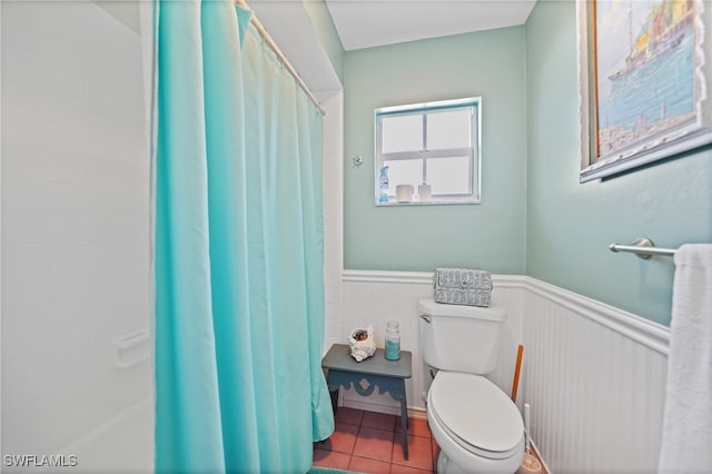 bathroom with a shower with curtain, tile patterned flooring, and toilet