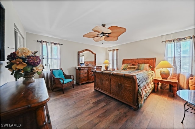 bedroom with multiple windows, dark wood-type flooring, and ceiling fan