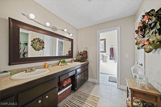 bathroom featuring tile patterned flooring, vanity, and a textured ceiling