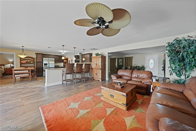 living room featuring hardwood / wood-style floors and ceiling fan