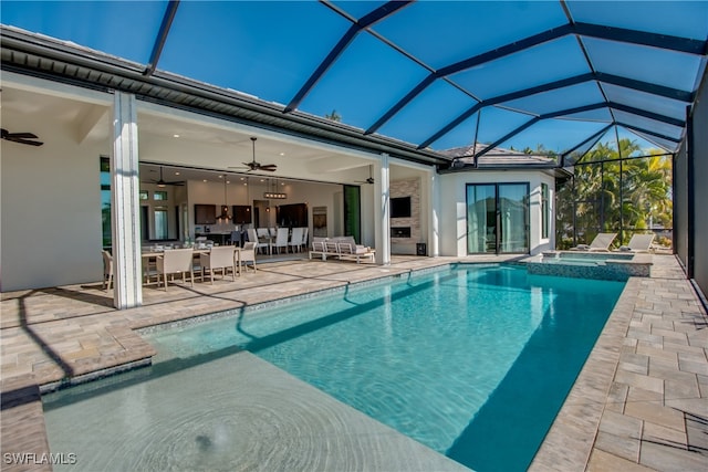 view of swimming pool with an outdoor living space, glass enclosure, ceiling fan, an in ground hot tub, and a patio area