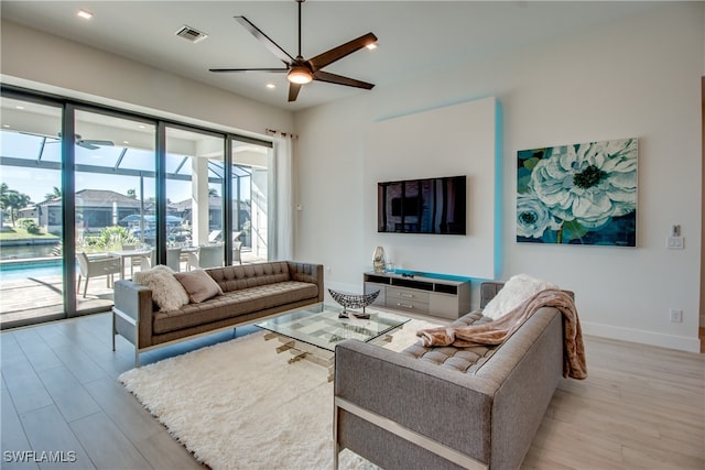 living room with light hardwood / wood-style flooring and ceiling fan